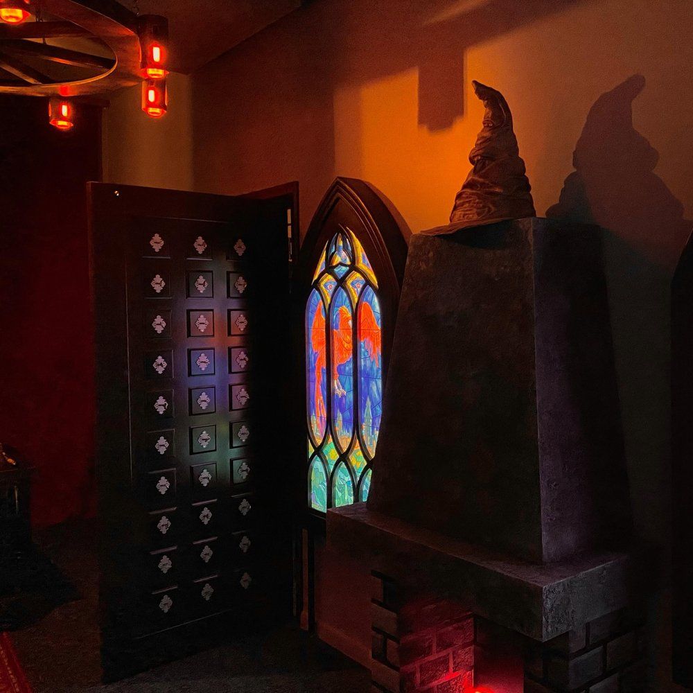 Wnętrze akademii magii: witraż z feniksem, czarodziejski kapelusz i komoda pełna szufladek – escape room Powrót czarnoksiężnika, Warszawa